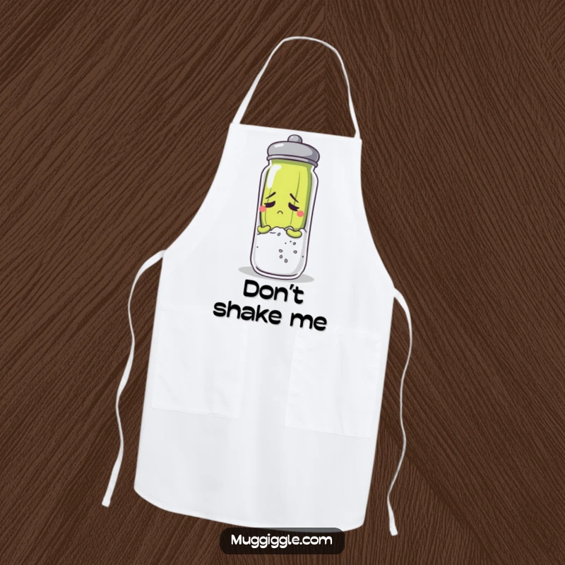 Funny anxious pickle character hiding behind a salt shaker while wearing a chef's apron.