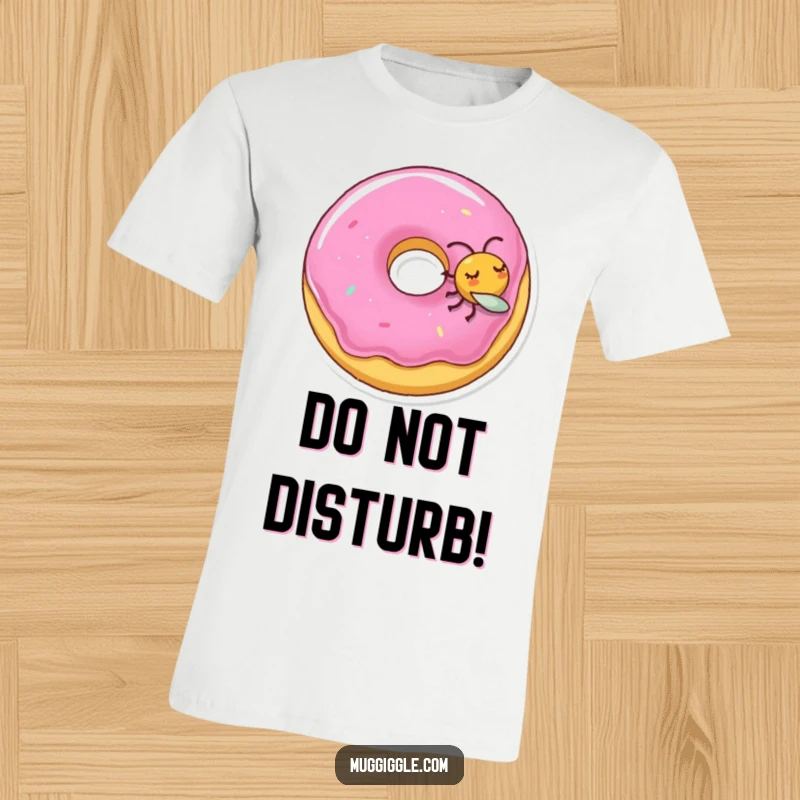 Funny T-shirt featuring a sleeping donut character disturbed by a playful, tiny fly, depicting a humorous moment.